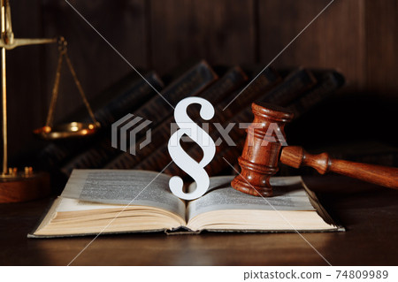 Paragraph sign and judge gavel with book in a courtroom Paragraph sign and judge gavel with book in a courtroom 74809989