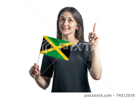 Happy young white woman holding flag of Jamaica and points thumbs up isolated on a white background 74812039