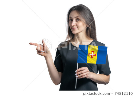 Happy young white woman holding flag Madeira and points to the left isolated on a white background Happy young white woman holding flag Madeira and points to the left isolated on a white background 74812110