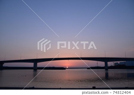 The rising sun rises between the bridge and the sea The rising sun rises between the bridge and the sea 74812404