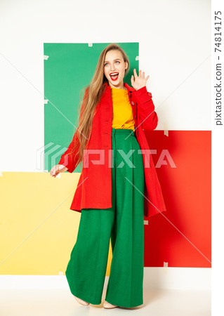 Happy fashionable woman in green pants in studio with white background 74814175