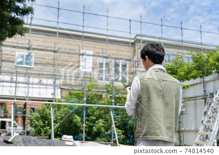 Male worker using a smartphone at a construction site 74814540