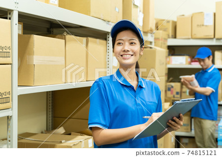 Young woman working in a warehouse Young woman working in a warehouse 74815121