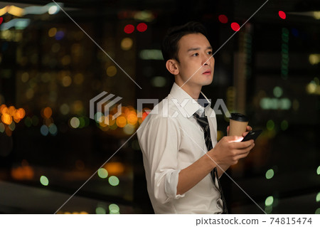 晚上在辦公室使用智能手機的商人 74815474