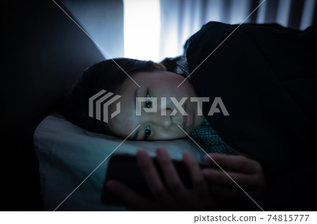 Asian woman on bed late at night and using mobile smartphone before sleep 74815777