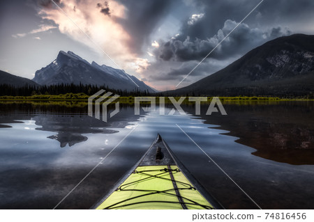 Kayaking in a beautiful lake surrounded by the Canadian Mountain 74816456