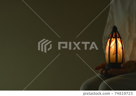 "Art Deco" lamp. Young woman lights. French antique (dim light room, soft focus) "Art Deco" lamp. Young woman lights. French antique (dim light room, soft focus) 74819723