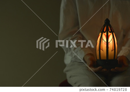 "Art Deco" lamp. Young woman lights. French antique (dim light room, soft focus) 74819728