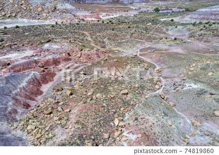 SUV car in rocky desert - aerial view SUV car in rocky desert - aerial view 74819860