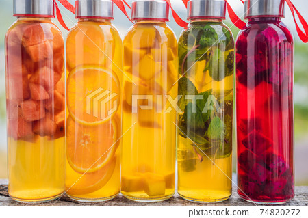 Cambucha with various fruits arranged in the form of a rainbow. Homemade fermented raw kombucha tea with different flavorings. Healthy natural probiotic flavored drink. LGBT 74820272