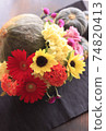 Halloween arrangement of flowers in a pumpkin bowl 74820413