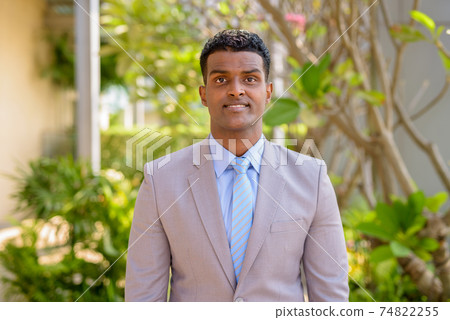 Happy African businessman wearing suit smiling outdoors 74822255