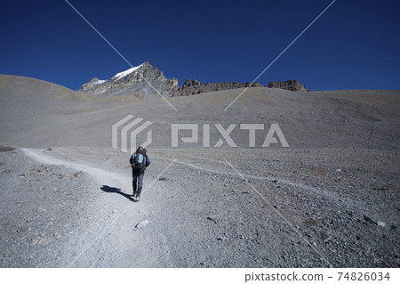 Hiker walking on trekking route on mountain 74826034
