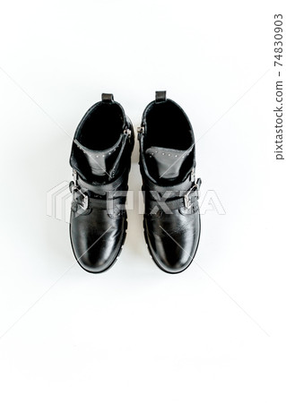 Black female boots on white background. Flat lay, top view minimal background. Fashion blog or magazine concept. Black female boots on white background. Flat lay, top view minimal background. Fashion blog or magazine concept. 74830903