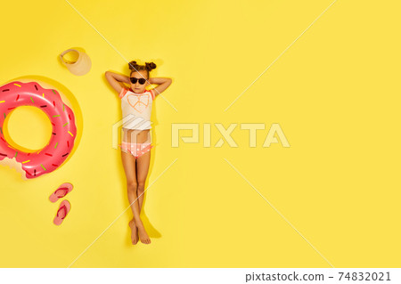 child girl in swimwear lying with rubber ring child girl in swimwear lying with rubber ring 74832021