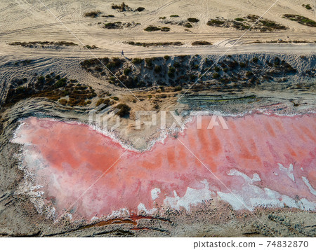 Pink lake in Ras al Khaimah surrounded by seaside, desert sand and mountains in the UAE 74832870