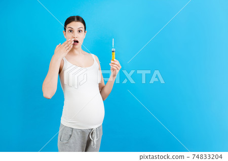 pregnant woman holding a syringe. A choice between injection and medications concept 74833204