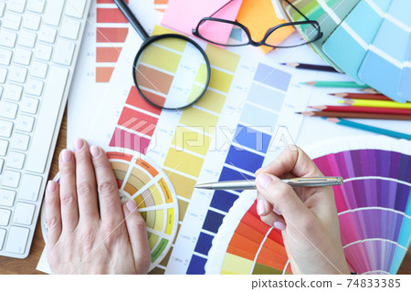 Designer develops color combinations on desktop closeup 74833385