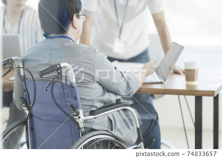 一個坐在輪椅上在辦公室里工作的人 74833657