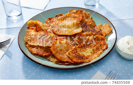 Belarusian potato pancakes draniki with sour cream at plate Belarusian potato pancakes draniki with sour cream at plate 74835509