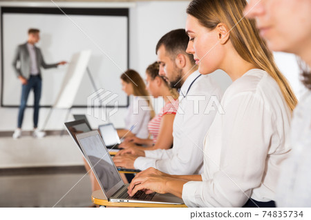 Side view of people with laptops Side view of people with laptops 74835734
