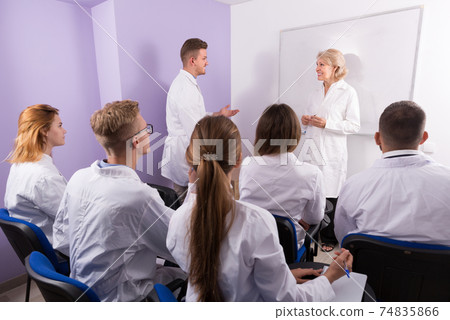 Confident male medical student talking with teacher 74835866