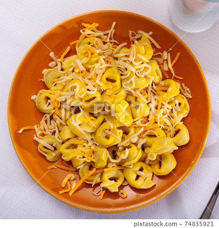 Tortellini garnished with grated cheese and pignoli Tortellini garnished with grated cheese and pignoli 74835921