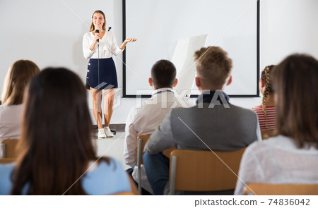 Female teacher lecturing to students Female teacher lecturing to students 74836042
