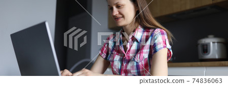 Woman in plaid shirt sit on chair at home and work at laptop 74836063