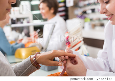 Nail technicians performing manicure 74836158