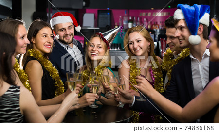 Portrait of cheerful females and males in caps and garlands Portrait of cheerful females and males in caps and garlands 74836168