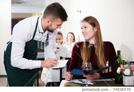 Welcoming waiter is taking order from cheerful woman Welcoming waiter is taking order from cheerful woman 74836570