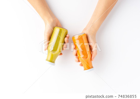 Overhead shot of woman hands holding bottles of fruit and vegetable juices isolated on white background Overhead shot of woman hands holding bottles of fruit and vegetable juices isolated on white background 74836855