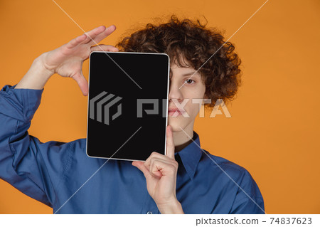 Caucasian young man's portrait isolated on yellow studio background with copyspace 74837623