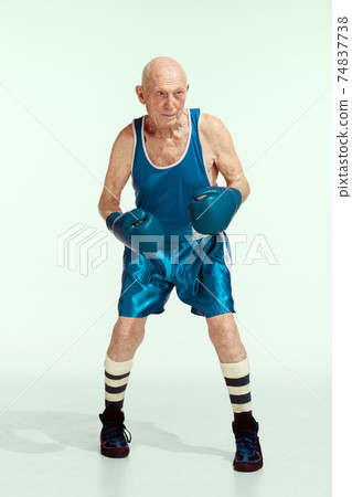 Senior man wearing sportwear boxing isolated on studio background. Concept of sport, activity, movement, wellbeing. Copyspace, ad. 74837738