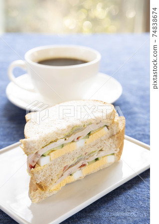 美味的火腿雞蛋三明治和熱咖啡 美味的火腿雞蛋三明治和熱咖啡 74838674