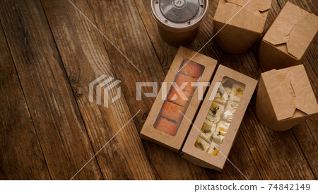 Asian food delivery. Packaging for sushi and woks. Food in paper containers Asian food delivery. Packaging for sushi and woks. Food in paper containers 74842149