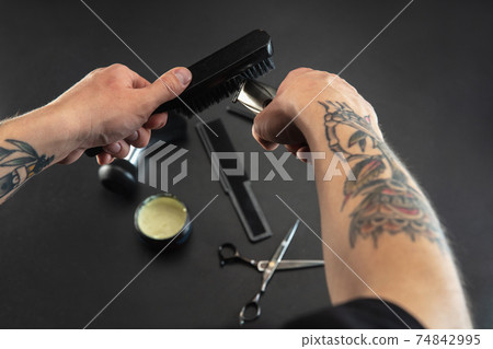 Hand of male barber with equipment set isolated on black table background. 74842995