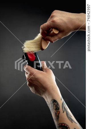 Hand of male barber with equipment set isolated on black table background. 74842997