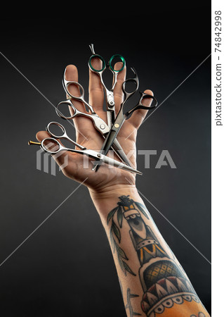 Hand of male barber with equipment set isolated on black table background. Hand of male barber with equipment set isolated on black table background. 74842998