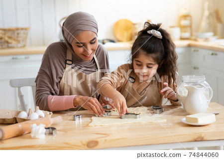 Pretty Young Muslim Lady Making Cookies With Her Little Daughter In Kitchen Pretty Young Muslim Lady Making Cookies With Her Little Daughter In Kitchen 74844060