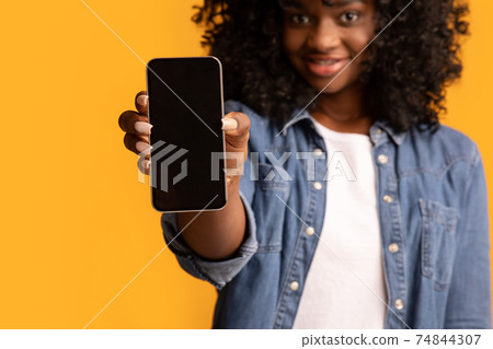 Closeup of black lady showing smartphone with empty screen Closeup of black lady showing smartphone with empty screen 74844307