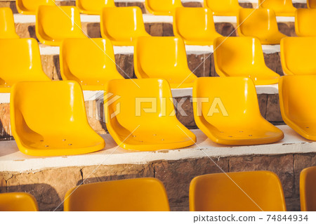 Stone steps with yellow plastic seats. Symbol of closed borders, empty hotels without tourists. Coronavirus COVID-19 quarantine. Hurghada, Egypt. 74844934
