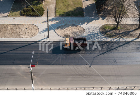Truck with a breakstone on a road in the city during road construction work. 74846806