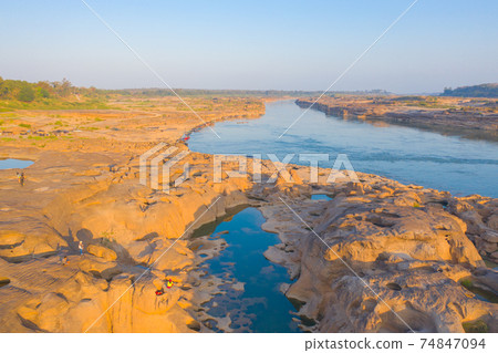 Aerial view of Sam Phan Bok, Ubon Ratchathani, Thailand. Dry rock reef in the Mekong River. Nature landscape background. Grand Canyon of Thailand. Aerial view of Sam Phan Bok, Ubon Ratchathani, Thailand. Dry rock reef in the Mekong River. Nature landscape background. Grand Canyon of Thailand. 74847094
