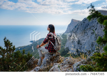 woman hiker enjoy the view at sunset mountain peak cliff woman hiker enjoy the view at sunset mountain peak cliff 74847385