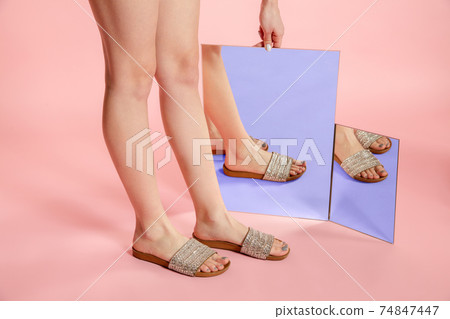 Female fit legs in fashionable shoes on coral pink background with mirror. Style and beauty concept. Close up. Female fit legs in fashionable shoes on coral pink background with mirror. Style and beauty concept. Close up. 74847447