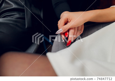 Lesbian couple of women on a date in a cafe. Two gay girlfriends hold hands and flirt in a bistro. Tactile sensations. Lgbt. Lesbian couple of women on a date in a cafe. Two gay girlfriends hold hands and flirt in a bistro. Tactile sensations. Lgbt. 74847712