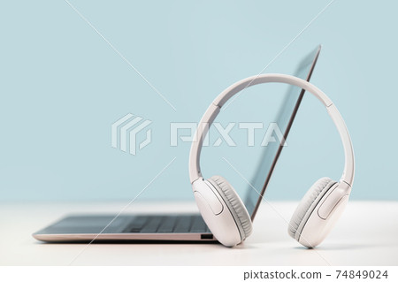 Laptop with headphones on white desk Laptop with headphones on white desk 74849024