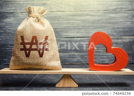 South korean won money bag and red heart on scales. Health life insurance financing concept. Reforming and preparing for new challenges. Funding healthcare. Support and life quality improvement. South korean won money bag and red heart on scales. Health life insurance financing concept. Reforming and preparing for new challenges. Funding healthcare. Support and life quality improvement. 74849236